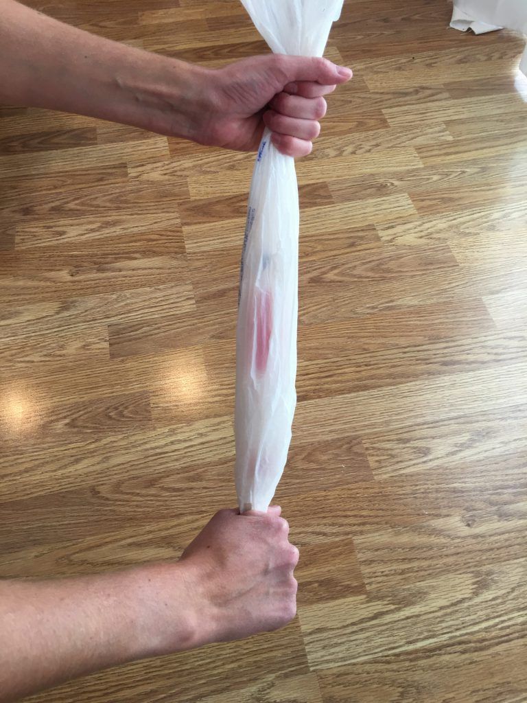 Bottom cut-out of plastic bag for putting on compression sock